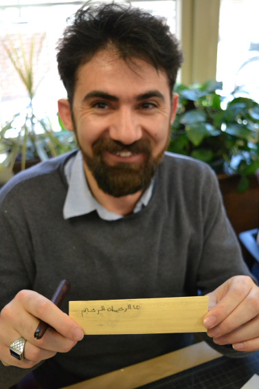 PhD student Cuma Ozkan shows off his palm-leaf manuscript leaf