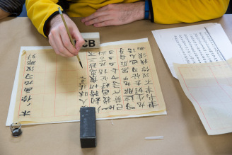 UI Religious Studies PhD candidate Peter Miller tries his hand at Chinese calligraphy at the Mellon Sawyer Chinese scroll workshop, led by British Library conservator emeritus Mark Barnard